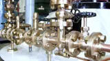 Polished brass valves and flanged fittings on an old boiler, with copper pipe running between them