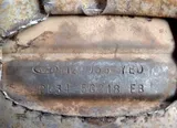Part number stamped into the steel shell of a used catalytic converter