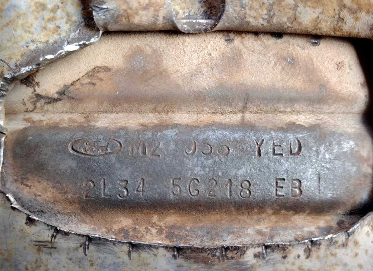 Part number stamped into the steel shell of a used catalytic converter