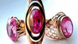 Three gold rings set with large red stones