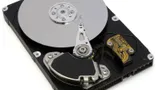 Hard disk drive with the cover removed, showing the platter, read/write arm, and magnet assembly
