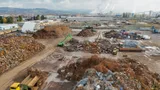 Aerial view of a large scrap metal recycling yard with sorted piles and heavy equipment