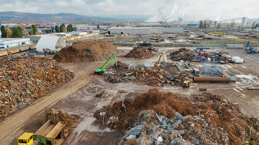 Aerial view of a large scrap metal recycling yard with sorted piles and heavy equipment