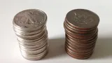 Two stacks of half dollars: silver coins with silver-white edges, and clad coins with a copper stripe on the edge
